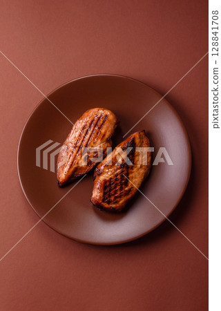 Chicken breast, grilled fillet, meat meal on a plate. Grilled poultry for dinner Chicken breast, grilled fillet, meat meal on a plate. Grilled poultry for dinner 128841708