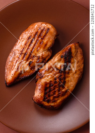 Chicken breast, grilled fillet, meat meal on a plate. Grilled poultry for dinner Chicken breast, grilled fillet, meat meal on a plate. Grilled poultry for dinner 128841712