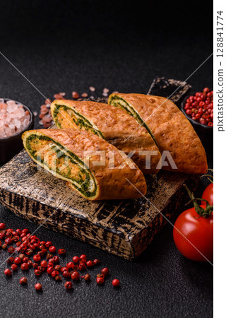 Roll of omelette, spinach, cheese and minced meat 128841774