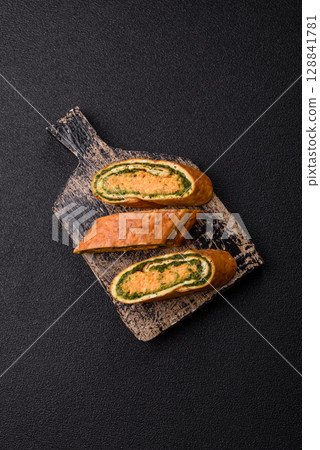Roll of omelette, spinach, cheese and minced meat 128841781