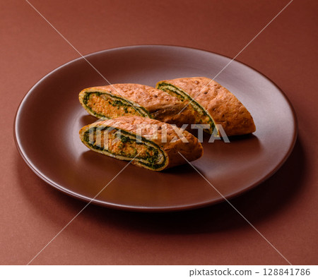 Roll of omelette, spinach, cheese and minced meat Roll of omelette, spinach, cheese and minced meat 128841786