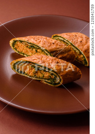 Roll of omelette, spinach, cheese and minced meat Roll of omelette, spinach, cheese and minced meat 128841789
