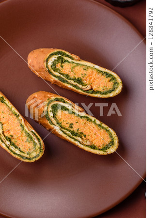 Roll of omelette, spinach, cheese and minced meat Roll of omelette, spinach, cheese and minced meat 128841792