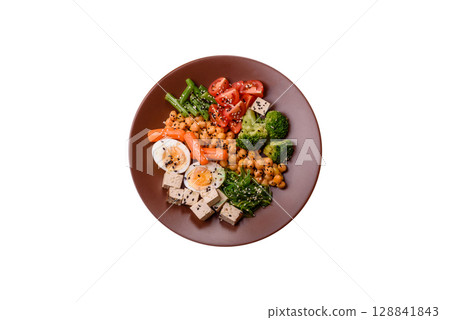 Vegan salad, bowls with chickpeas, broccoli, tomatoes, tofu cheese and boiled eggs Vegan salad, bowls with chickpeas, broccoli, tomatoes, tofu cheese and boiled eggs 128841843