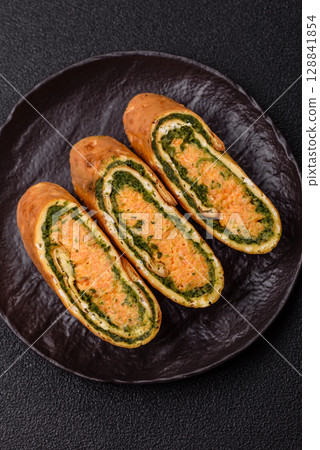 Roll of omelette, spinach, cheese and minced meat Roll of omelette, spinach, cheese and minced meat 128841854