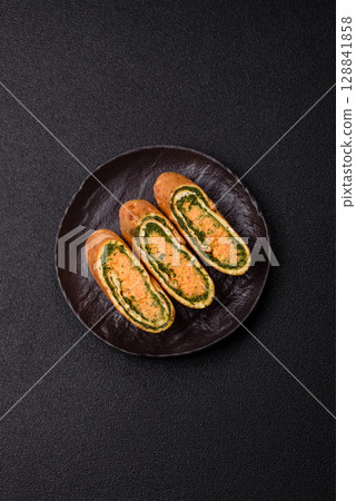Roll of omelette, spinach, cheese and minced meat Roll of omelette, spinach, cheese and minced meat 128841858