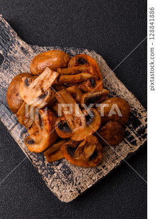 Food, baked mushrooms champignon slices with sauce and spices 128841886