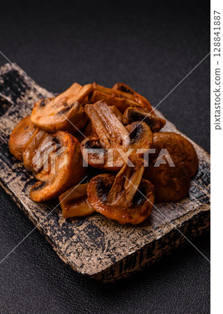 Food, baked mushrooms champignon slices with sauce and spices Food, baked mushrooms champignon slices with sauce and spices 128841887