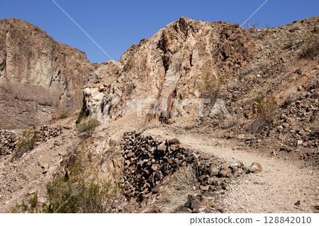 Desert Trail in Rocky Canyon Under Clear Blue Sky 128842010