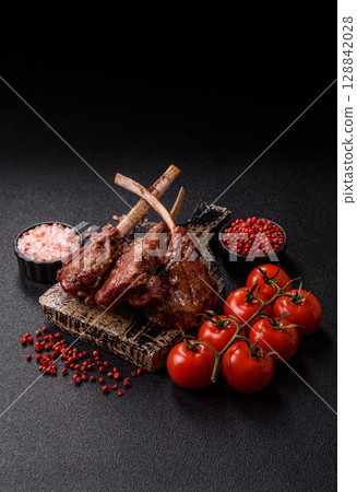 Juicy meat on the bone or rack of lamb. Grilled veal with salt, spices and herbs 128842028