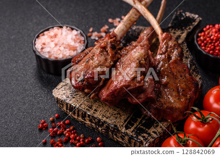 Juicy meat on the bone or rack of lamb. Grilled veal with salt, spices and herbs Juicy meat on the bone or rack of lamb. Grilled veal with salt, spices and herbs 128842069