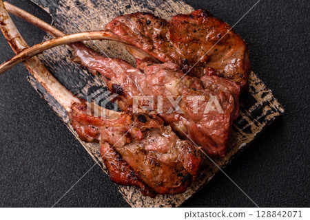 Juicy meat on the bone or rack of lamb. Grilled veal with salt, spices and herbs 128842071