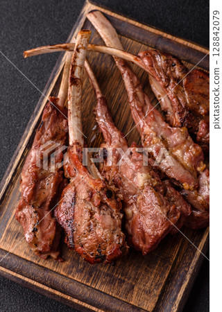Juicy meat on the bone or rack of lamb. Grilled veal with salt, spices and herbs Juicy meat on the bone or rack of lamb. Grilled veal with salt, spices and herbs 128842079