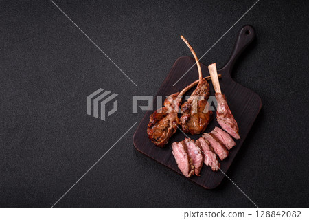 Juicy meat on the bone or rack of lamb. Grilled veal with salt, spices and herbs Juicy meat on the bone or rack of lamb. Grilled veal with salt, spices and herbs 128842082