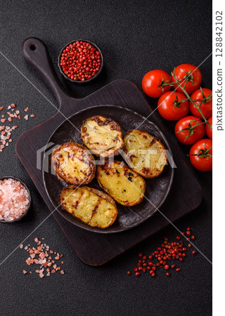 Food, potatoes cut in halves or slices grilled. Cooked baked potatoes Food, potatoes cut in halves or slices grilled. Cooked baked potatoes 128842102