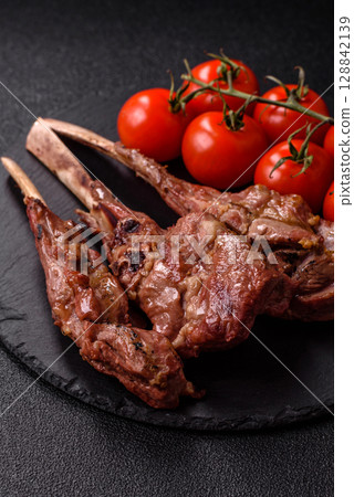 Juicy meat on the bone or rack of lamb. Grilled veal with salt, spices and herbs Juicy meat on the bone or rack of lamb. Grilled veal with salt, spices and herbs 128842139