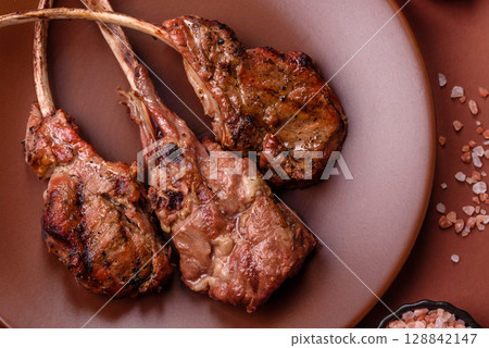 Juicy meat on the bone or rack of lamb. Grilled veal with salt, spices and herbs 128842147