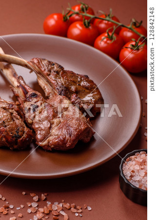 Juicy meat on the bone or rack of lamb. Grilled veal with salt, spices and herbs 128842148