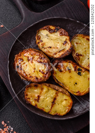 Food, potatoes cut in halves or slices grilled. Cooked baked potatoes 128842202