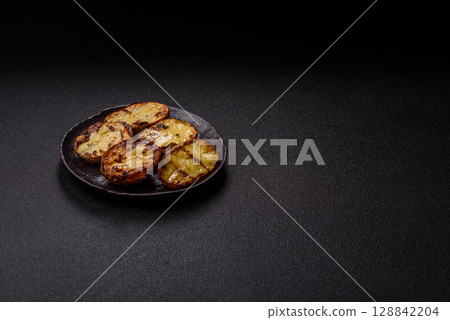 Food, potatoes cut in halves or slices grilled. Cooked baked potatoes 128842204