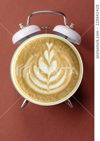 It's coffee time, the signal to drink your morning cappuccino or latte. Concept with a cup of coffee It's coffee time, the signal to drink your morning cappuccino or latte. Concept with a cup of coffee 128842428