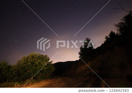 A view of the stars of the Milky Way with a mountain top in the foreground.Perseid Meteor Shower observation 128842583