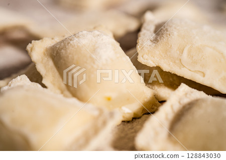 Fresh homemade uncooked ravioli pasta sprinkled with flour Fresh homemade uncooked ravioli pasta sprinkled with flour 128843030
