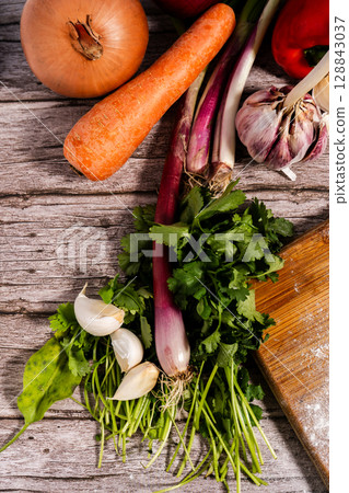 Fresh vegetables lying on rustic wooden table ready for cooking. Vertical Orientation 128843037