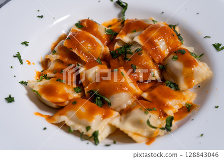 Ravioli pasta with tomato sauce and parsley sprinkled on top Ravioli pasta with tomato sauce and parsley sprinkled on top 128843046