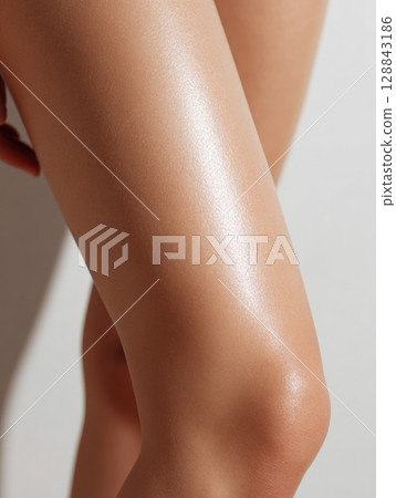 Close-up of smooth, glowing legs with a beautiful sheen, emphasizing healthy skin and a luxurious feel. Ideal for beauty, skincare, hydration, tanning, and cosmetic product promotions 128843186