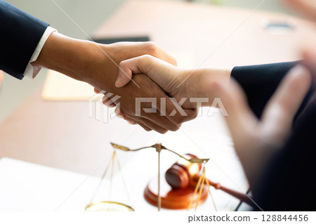 Handshake Agreement. Diverse professionals sealing a deal in a law office. Handshake Agreement. Diverse professionals sealing a deal in a law office. 128844456