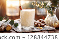 Elegant fall mocktail with cinnamon in crystal glass, ginger and eucalyptus on marble, soft focus and clean tones 128844738