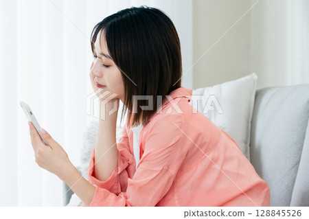 Young woman looking at a smartphone 128845526