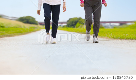 Two middle-aged women walking in sportswear 128845780