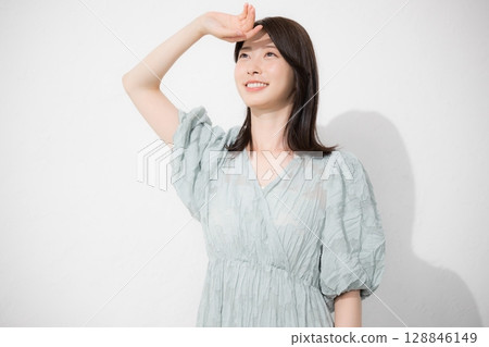 一名身穿短袖的女性試圖在夏天保護自己免受陽光照射,在春夏季保護自己免受紫外線照射 一名身穿短袖的女性試圖在夏天保護自己免受陽光照射,在春夏季保護自己免受紫外線照射 128846149