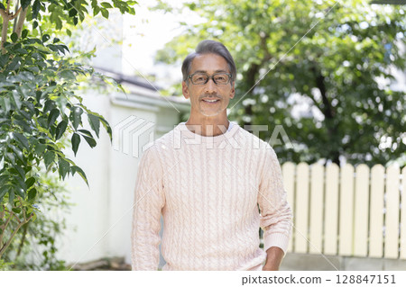 A man in his early 60s smiling at the camera 128847151