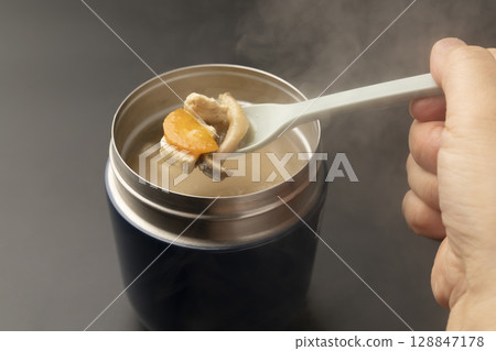 Lift up the warm miso soup in a soup jar with a spoon 128847178