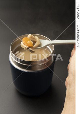 Lift up the warm miso soup in a soup jar with a spoon 128847179