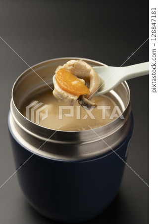 Lift up the warm miso soup in a soup jar with a spoon 128847181