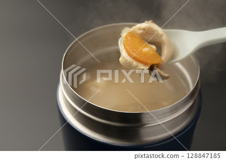 Lift up the warm miso soup in a soup jar with a spoon 128847185
