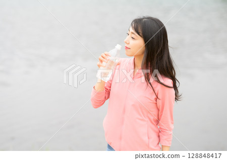 水邊拿著塑膠瓶的女人 128848417