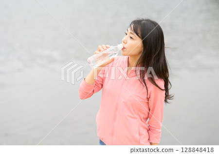 水邊拿著塑膠瓶的女人 水邊拿著塑膠瓶的女人 128848418