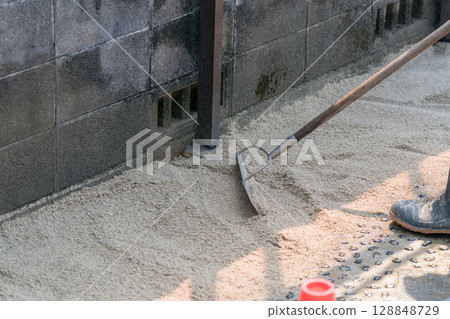 建築工人用耙子平整沙子 建築工人用耙子平整沙子 128848729