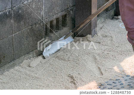 建築工人用耙子平整沙子 建築工人用耙子平整沙子 128848730