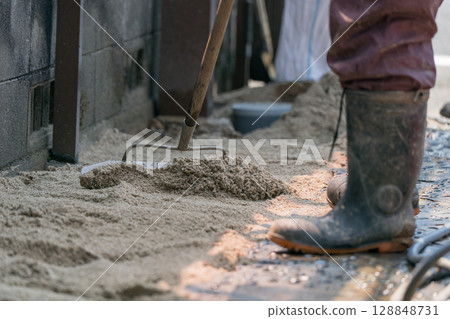 建築工人用耙子平整沙子 建築工人用耙子平整沙子 128848731