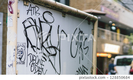Signboard covered with graffiti and stickers - back 128850684