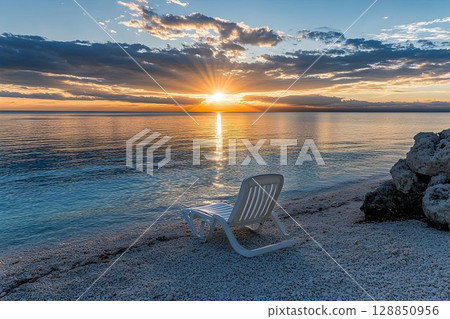 Serene Sunset Beachscape with Solitary Chair 128850956