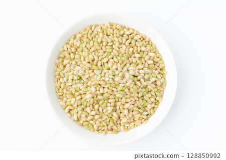 Green rice in a plate on a white background 128850992
