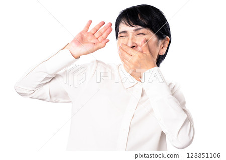 Senior woman covering her mouth with her hand to hold back laughter Senior woman covering her mouth with her hand to hold back laughter 128851106