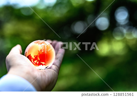 水晶球高高聳立在美麗的新綠之上。生態圖片。全球暖化圖片。黑暗。 128851561
